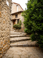 Fototapeta na wymiar calle con escaleras y paredes de piedra con árboles a un lado
