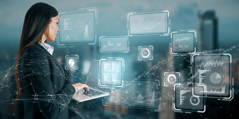 Attractive young european businesswoman using laptop with creative business chart hologram on blurry city background. Innovation, finance, trade, future, ai and technology concept. Double exposure.