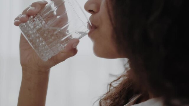 Close up profile portrait of a young woman drinking water