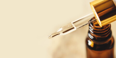 Pipette with cosmetics on a beige background
