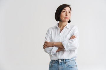 European mature woman looking aside while posing with arms crossed