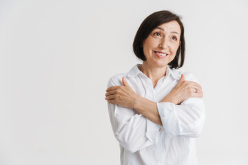 European mature woman smiling while posing with arms crossed