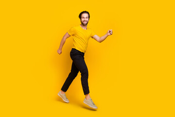 Fototapeta na wymiar Full length profile side photo of young cheerful guy have fun action movement runner isolated over yellow color background
