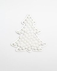 Christmas tree shape frame filled with snow sparkle balls ornaments against white background. Minimal winter holidays and New Year layout.