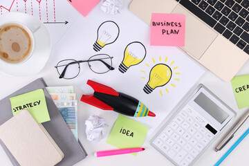 Flat lay composition with stationery, money and toy rocket on white table. Startup concept
