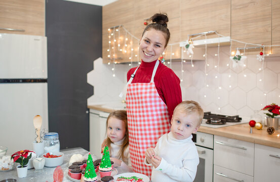 Brother And Sister Making Cupcakes With Their Mom