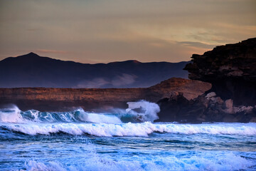 Brechende Wellen am Strand von Playa del Viejos Reyes auf Fuerteventura während des Sonnenaufgangs