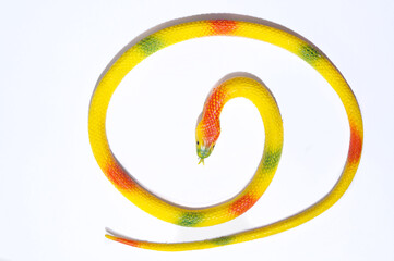 Isolated yellow bright snake on a white background. A toy for children.