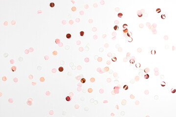 Happy New Year and Xmas or birthday festive composition. Golden pink confetti on white table...