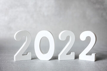 Decorative white wooden numbers 2022 isolated on grey background. Happy new year 2022. Banner