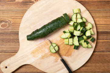 cutting fresh cucumber on a chop board