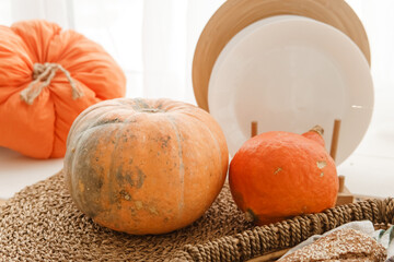 Kitchen countertop by the window in a bright room. Orange pumpkins, bread and pasta on the...