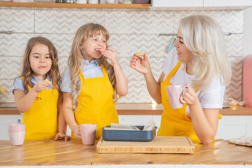 Caucasian Mom and two daughters taste the cookies