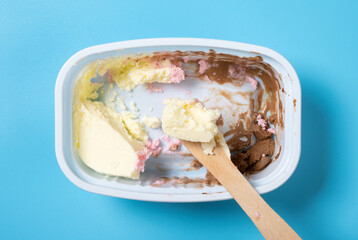 eating cup of multicolor ice cream on blue background