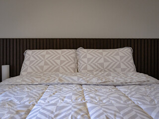 detail of pillows and headboard in slatted dark wood