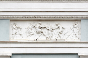 Relief with dancing people on the facade of old building in Kyiv Ukraine