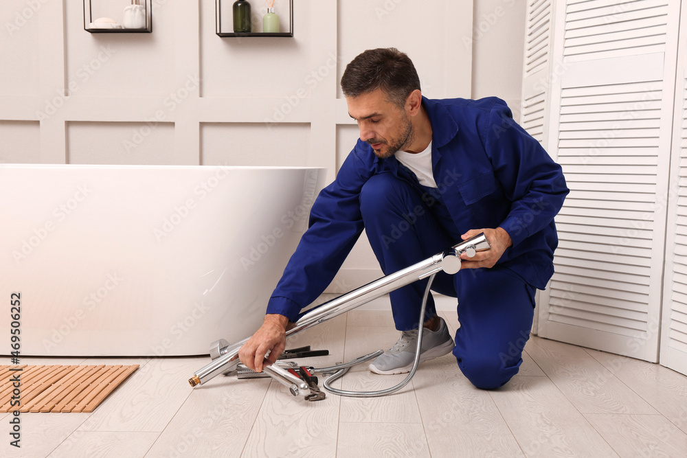 Wall mural Professional plumber installing water tap in bathroom