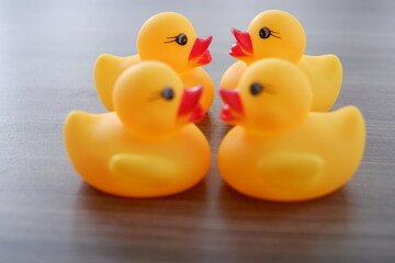 yellow duck toy on a wooden texture background with various combinations of formations and angles