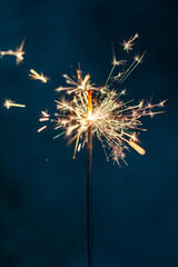 Christmas bengal fire sparkles against the black background.