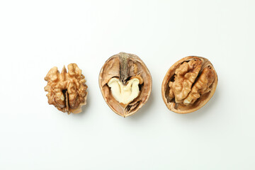 Walnuts with nutshell on white background, top view