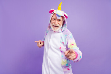 Photo of funky cool retired man nightwear overall smiling pointing finger you empty space isolated purple color background