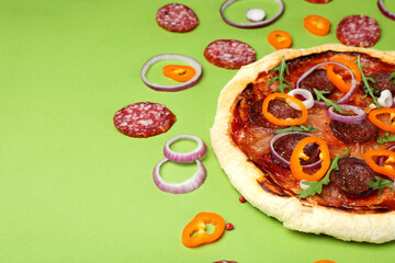 Concept of tasty food with Salami pizza on green background
