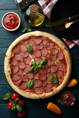 Concept of tasty food with Salami pizza on wooden table