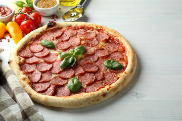 Concept of tasty food with Salami pizza on white wooden background