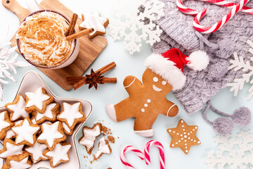 Gingerbread man, cookies and Christmas decor on pastel background.