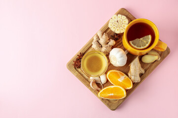 Concept of treatment colds with honey and garlic on pink background
