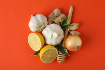 Concept of treatment colds with honey and garlic on orange background