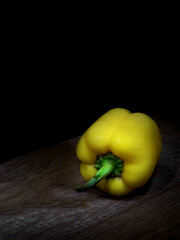 Yellow bell pepper on wooden board