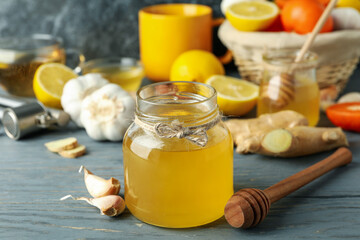 Concept of treatment colds with honey and garlic on gray wooden table
