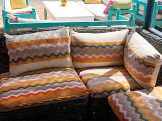 Hurghada, Egypt - September 22, 2021: Beach bar near the red sea. Sofas on the sand with multi-colored pillows. Close-up.