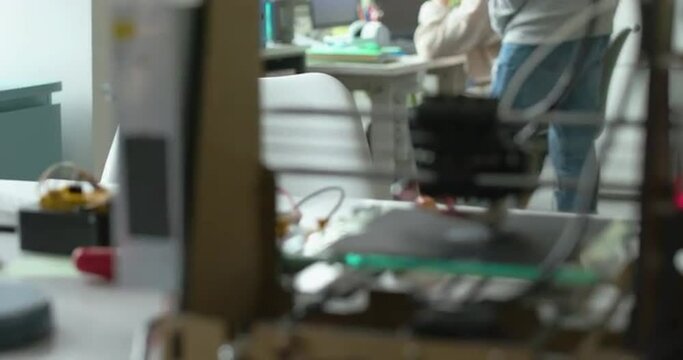 3D printer printing a prototype and engineering students