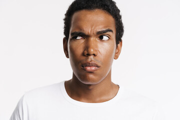 Young black man dressed t-shirt looking aside and frowning