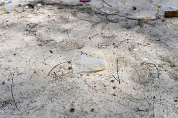 Used plastic cup on the beach,dirty waste