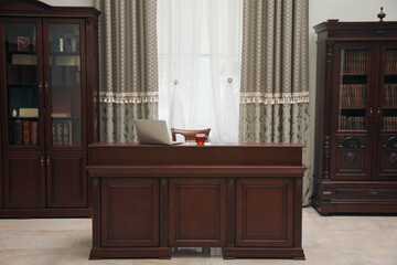 Library reading room interior with wooden bookcases and laptop on table