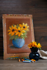 Yellow flowers, beautiful drawing and set of colorful pastels on wooden table