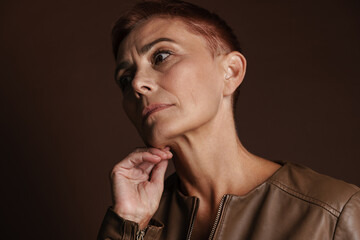 Senior ginger woman with short hair posing and looking aside