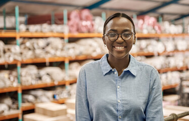 Smiling young African woman standing in her large warehouse