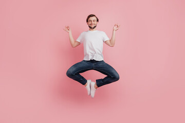 Full size photo of young happy excited smiling positive man jump dream dreamy yoga isolated on pink color background