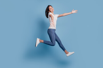 Fototapeta na wymiar Portrait of adorable charming cute lady jump run hands invite embrace on blue background