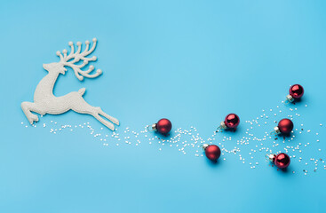 Christmas card with a deer, shining stars and Christmas balls.