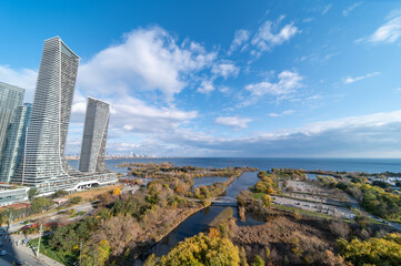 Drone photo of Humber bay lakeshore and Parklawn rd area with blue skies with broken clouds fall tree colours yellow and orange green as well 