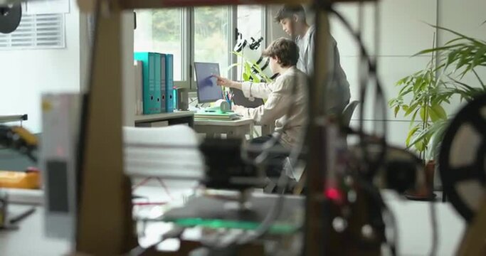 3D printer printing a prototype and engineering students