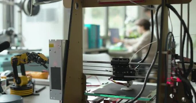 3D printer printing a prototype and engineering students