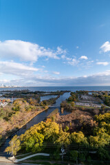 Fototapeta na wymiar Drone views of Humber bay park overlooking the lake and fall tree colours by Parklawn and lakeshore with blue sky and clouds 