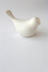 White bird on a white background. The symbolic figure of a bird. Free space for text. Vertical photo.