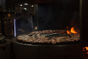 Spare ribs cooking on barbecue grill. Grill restaurant open kitchen. Chef cooking ribs in BBQ